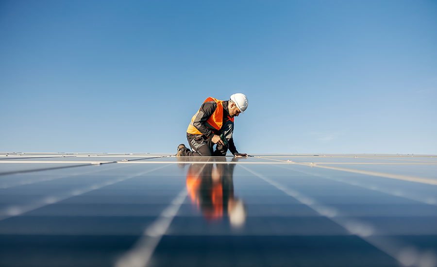 A person doing repair works in the rooftop of the solar panel